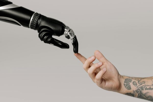 Berührende Roboterhand und menschliche Hand - Ratgeber KI im Marketing: WeLikeWeb